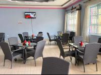 Un comedor con mesas y sillas y un televisor. en Mong'are Lodge and Restaurant, Narok, en Narok