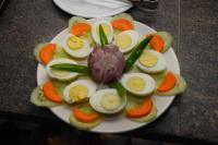 a plate of eggs and vegetables on a table at Hotel Kek Grand Pvt Ltd in Chennai