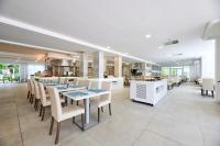 ein Esszimmer mit Tischen und Stühlen und eine Küche in der Unterkunft AluaSun Continental Park Hotel & Apartments in Playa de Muro