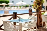 einen Tisch und Stühle auf einem Balkon mit Pool in der Unterkunft AluaSun Continental Park Hotel & Apartments in Playa de Muro