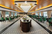 a dining room with tables and green chairs at Catherine Cruises Ha Long Bay in Ha Long