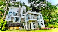 ein großes weißes Gebäude mit einer Veranda und einem Hof in der Unterkunft Biệt Thự Lan Anh Đà Lạt in Da Lat