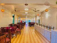 um restaurante com mesas, cadeiras e um bar em Royal Resort, itahari em Itahari