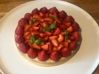 Un pastel con fresas en un plato sobre una mesa en Le Clos des Songes, en Blaru