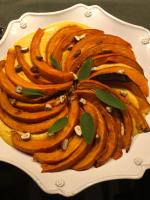 Un plato blanco cubierto con un pastel con hojas encima. en Le Clos des Songes, en Blaru