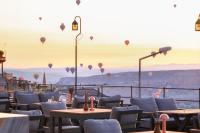 Un restaurante con globos aerostáticos en el cielo. en Breeze Of Cappadocia, en Uchisar