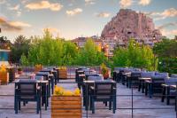 Una fila de mesas y sillas con una montaña al fondo. en Breeze Of Cappadocia, en Uchisar