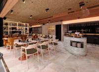 Un restaurante con mesas y sillas y un bar. en ibis Styles Lisboa Aeroporto, en Lisboa