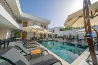 una piscina con mobili da giardino e ombrelloni di Paradise Gündoğan Hotel a Bodrum City