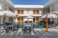 un hotel con piscina con tavoli, sedie e ombrelloni di Paradise Gündoğan Hotel a Bodrum City