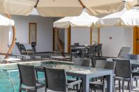 una piscina con tavoli, sedie e ombrelloni di Paradise Gündoğan Hotel a Bodrum City