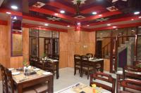 Un restaurante con paredes de madera y mesas y sillas. en Sarahan Holiday Inn, en Sarāhan