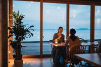 dos personas sentadas en una mesa en un restaurante en Colorit GOTO ISLANDS, en Goto