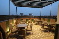 eine Terrasse mit Tischen und Stühlen auf einem Balkon in der Unterkunft Hotel Tango Traxx in Amritsar