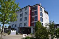 un edificio de apartamentos con fachada en rojo y blanco en Allgäuhotel Memmingen Nord, en Memmingen