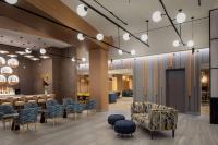 eine Lobby mit Stühlen, Tischen und einer Bar in der Unterkunft Hampton Inn by Hilton New York Times Square in New York
