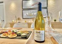 una botella de vino sentada junto a un plato de comida en Hotel Particulier Les Rêveries du CLOS Vignes &Spa Adult Only, en Pommard