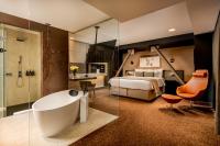 Un baño con bañera y un dormitorio con cama. en Kronwell Brasov Hotel, en Brasov