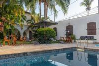 a pool with chairs and tables and an umbrella at Pousada Boulevard in Cabo Frio