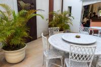 a patio with a table and chairs and palm trees at Pousada Boulevard in Cabo Frio