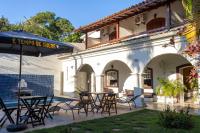 a patio with tables and chairs and an umbrella at Pousada Boulevard in Cabo Frio