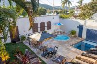 a patio with a table and chairs and a swimming pool at Pousada Boulevard in Cabo Frio