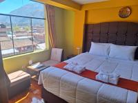 Un dormitorio con una cama grande y una ventana grande. en Chaska valle Inn, en Urubamba
