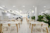 a restaurant with white tables and white chairs at 苏州山塘街华贸姑苏里酒店公寓 in Suzhou