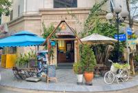 Un restaurante con mesas y sombrillas y una bicicleta delante. en Căn Hộ The Manor Crown, en Thôn Trường Giang