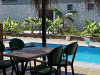 Una mesa y sillas junto a una piscina. en Aden Garden Otel, en Cesme