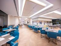a dining room with blue chairs and tables at Wyndham Jomtien Pattaya in Na Jomtien