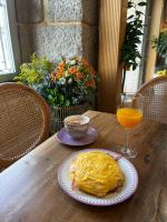 una mesa con un plato de comida y un vaso de jugo de naranja en Christine Boutique Hotel, en El Barraco