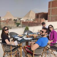 a group of people sitting around a table with pyramids in the background at Eagles Pyramids View in Cairo