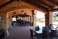 een patio met tafels en stoelen in een bakstenen gebouw bij Palmira Hotel in Yelizavetovka