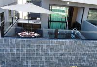 a table and chairs with an umbrella on a building at Villas do Porto APTO 05 - Porto de Galinha in Porto De Galinhas
