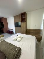 a bedroom with a white bed with a television on it at Villas do Porto APTO 05 - Porto de Galinha in Porto De Galinhas