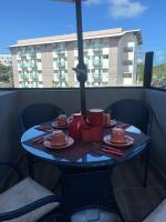 a table with plates and utensils on a balcony at Villas do Porto APTO 05 - Porto de Galinha in Porto De Galinhas