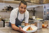 a man in a kitchen holding a plate of food at JetPark Auckland Airport Hotel in Auckland