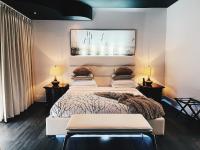 Un dormitorio con una cama y dos mesas y dos lámparas. en Hotel Kutuma, en Montreal