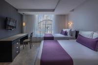 a hotel room with two beds and a desk at Gamma Puebla Señorial Centro in Puebla