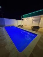a blue swimming pool in a room at night at Pousada QUERÊNCIA FRANCÊS in Marechal Deodoro