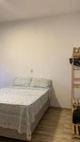 a bedroom with a bed and a white wall at Pousada QUERÊNCIA FRANCÊS in Marechal Deodoro