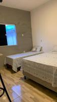 two beds in a room with a window at Pousada QUERÊNCIA FRANCÊS in Marechal Deodoro
