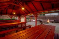 a patio with wooden benches and a fire place at Malachit Karpacz SPA Hotel in Karpacz