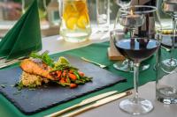 a plate of food on a table with a glass of wine at Malachit Karpacz SPA Hotel in Karpacz