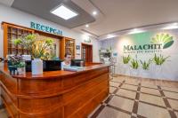 a woman sitting at a reception counter in a salon at Malachit Karpacz SPA Hotel in Karpacz