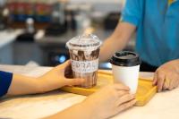 una persona sosteniendo una taza de café y una taza de cacao en Krabi SeaBass Hotel, en Krabi