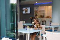 una mujer sentada en una mesa en un restaurante en Krabi SeaBass Hotel, en Krabi