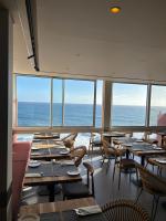 Un comedor con mesas y sillas y el océano. en Boutique Hotel Jardim Do Mar, en Jardim do Mar