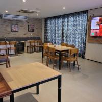 Apartamentos Landscape Beira Mar في فورتاليزا: غرفة طعام مع طاولات وكراسي وتلفزيون